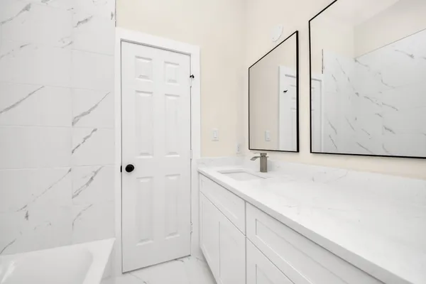 a bathroom with a granite countertop sink a mirror and shower