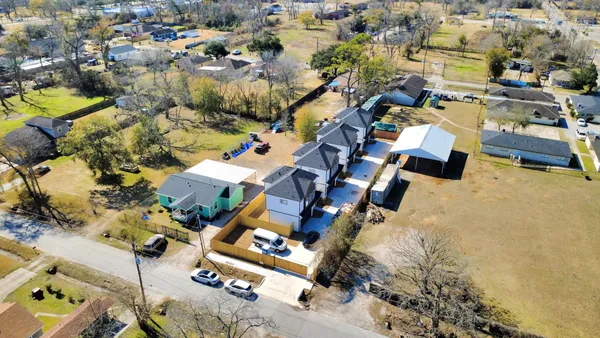 an aerial view of residential building with parking and yard