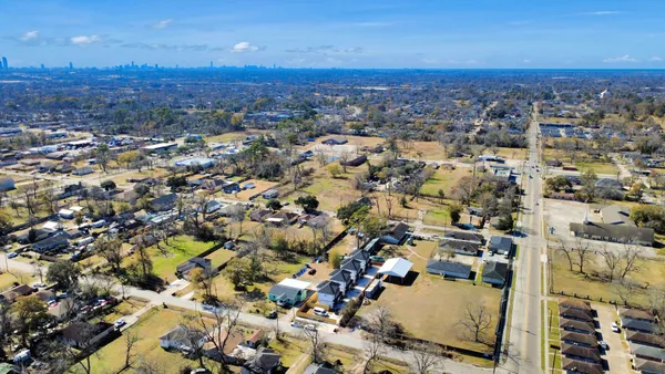 an aerial view of residential building with parking and yard