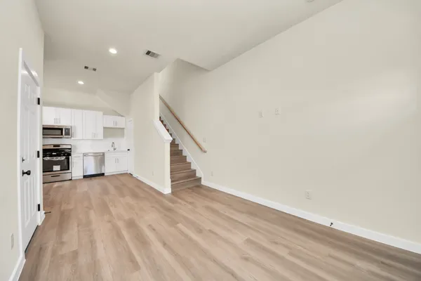 an empty room with wooden floor and entrance