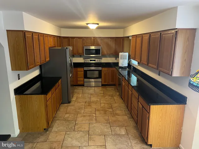 a kitchen with stainless steel appliances granite countertop a refrigerator and a sink