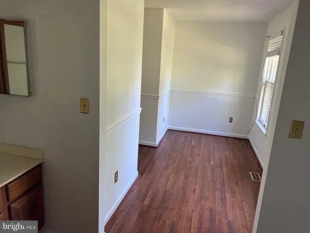 a view of a room with wooden floor and a window