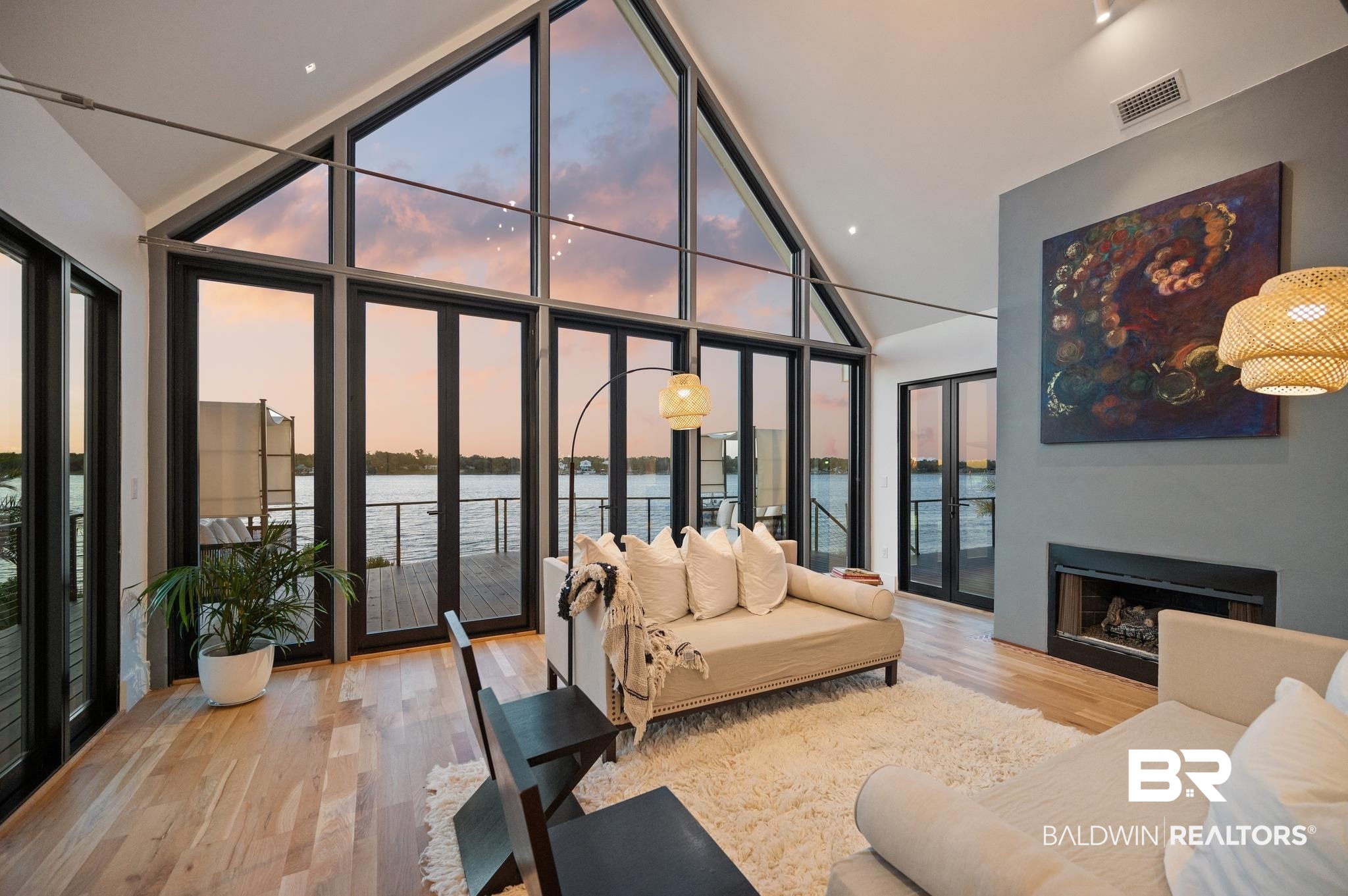 33349 River Road Orange Beach, AL 36561 - Photo 32 of 61 Vaulted ceiling living area featuring expansive floor-to-ceiling windows, wood-finish flooring, a built-in fireplace, and direct access to an exterior deck