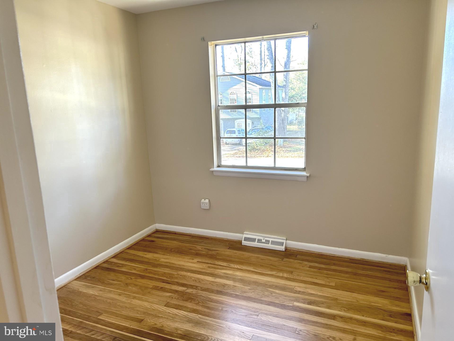 1527 Patuxent Manor Road Davidsonville, MD 21035 - Photo 11 of 36 an empty room with wooden floor and windows