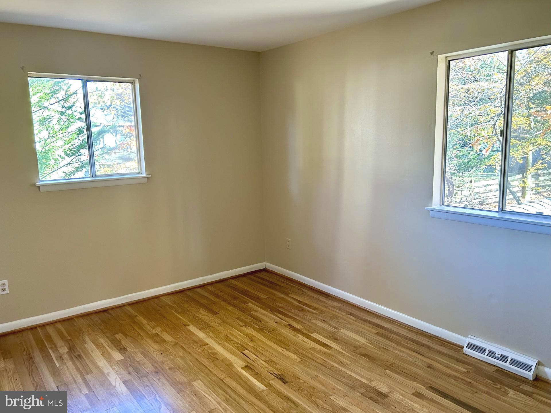 1527 Patuxent Manor Road Davidsonville, MD 21035 - Photo 12 of 36 an empty room with wooden floor and windows