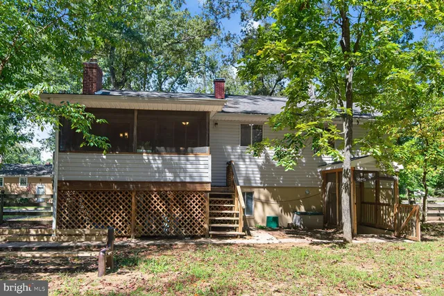 a view of backyard with wooden fence and a bench