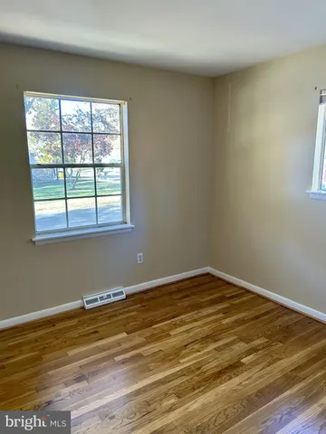 a view of a room with wooden floor and a window
