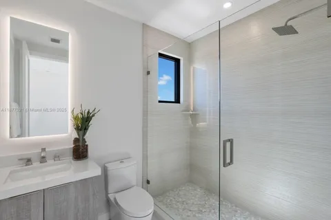 a bathroom with a granite countertop sink a toilet and shower