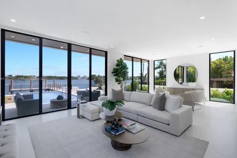 a living room with furniture and floor to ceiling windows