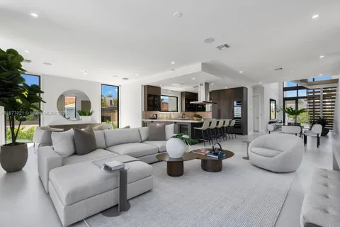 a living room with furniture and a view of kitchen