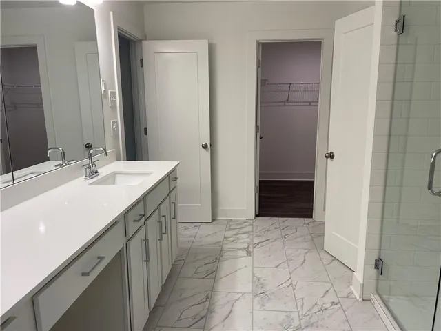 a spacious bathroom with a mirror sink and shower