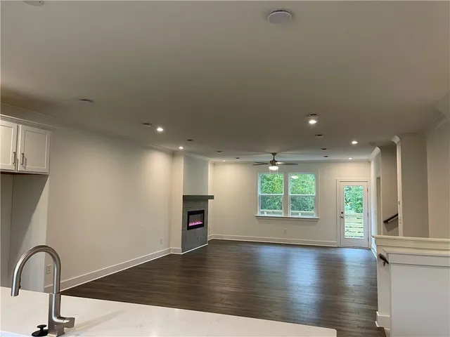 a view of an empty room with window and wooden floor