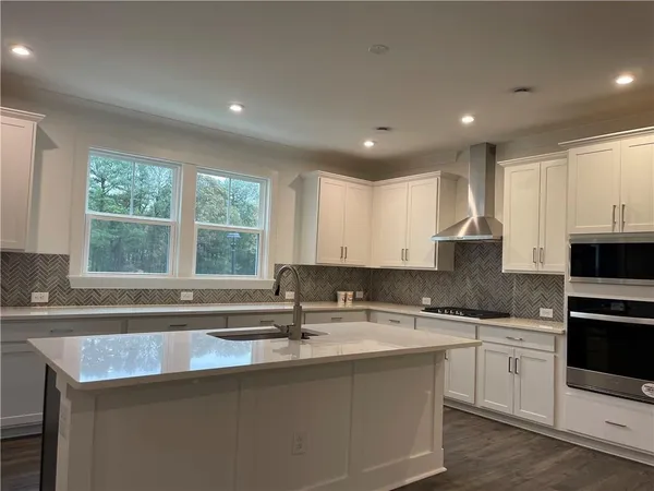 a kitchen with stainless steel appliances granite countertop a sink a stove a microwave a counter top and cabinets