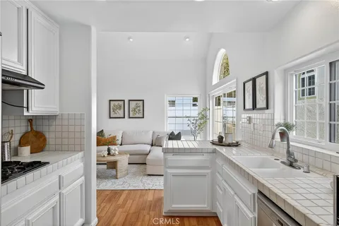 a kitchen with a sink dishwasher and a stove with wooden floor