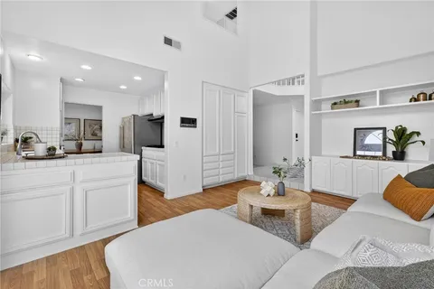 a living room with furniture and view of kitchen