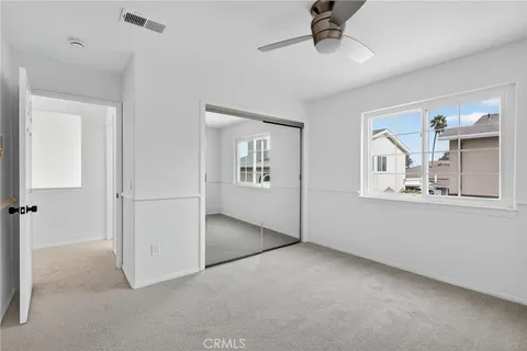 an empty room with windows and cabinet