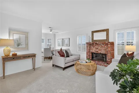 a living room with furniture a fireplace and a potted plant
