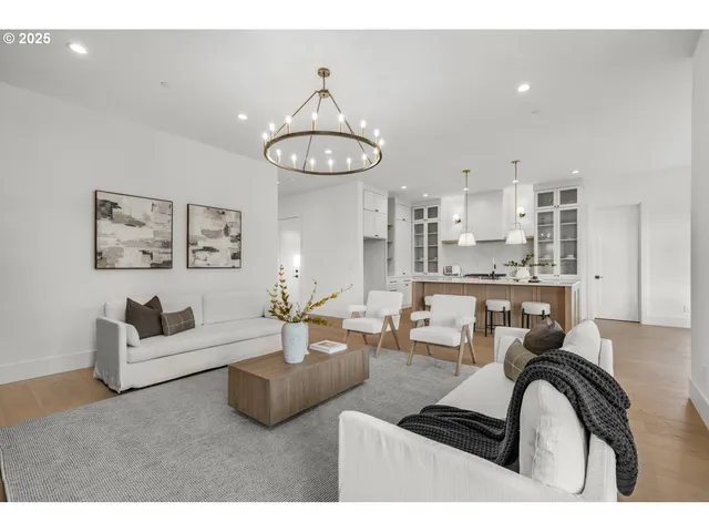 a living room with furniture a rug and kitchen view