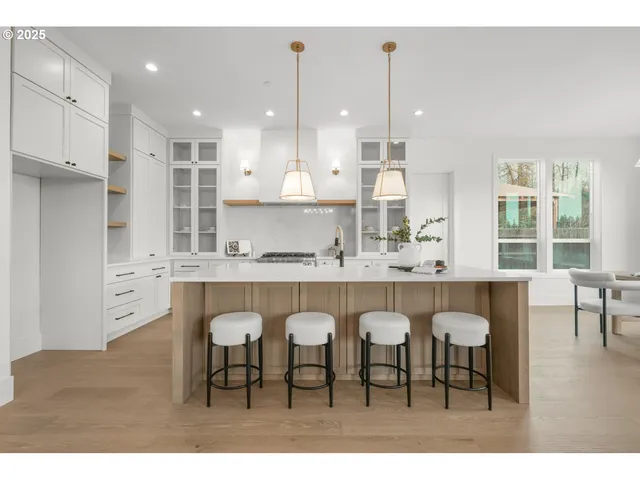 a large kitchen with dining table chairs and white appliances
