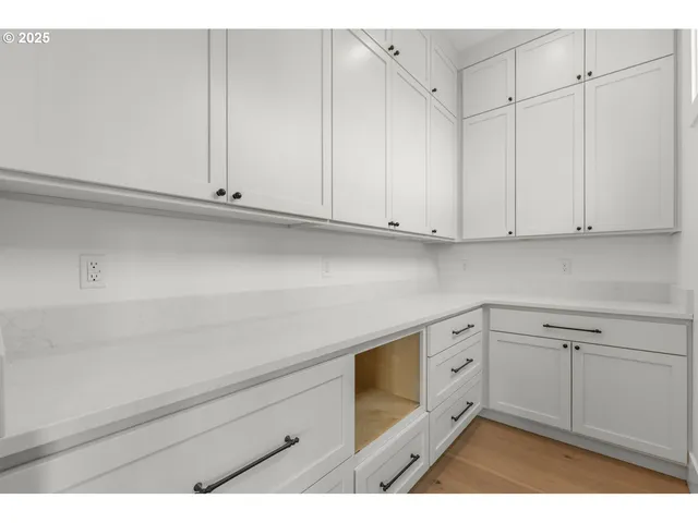 a kitchen with white cabinets and white appliances