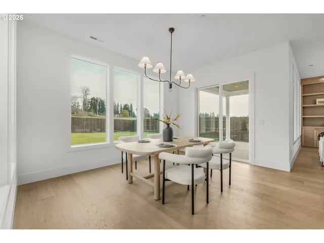 a dining room with wooden floor a chandelier a wooden table and chairs