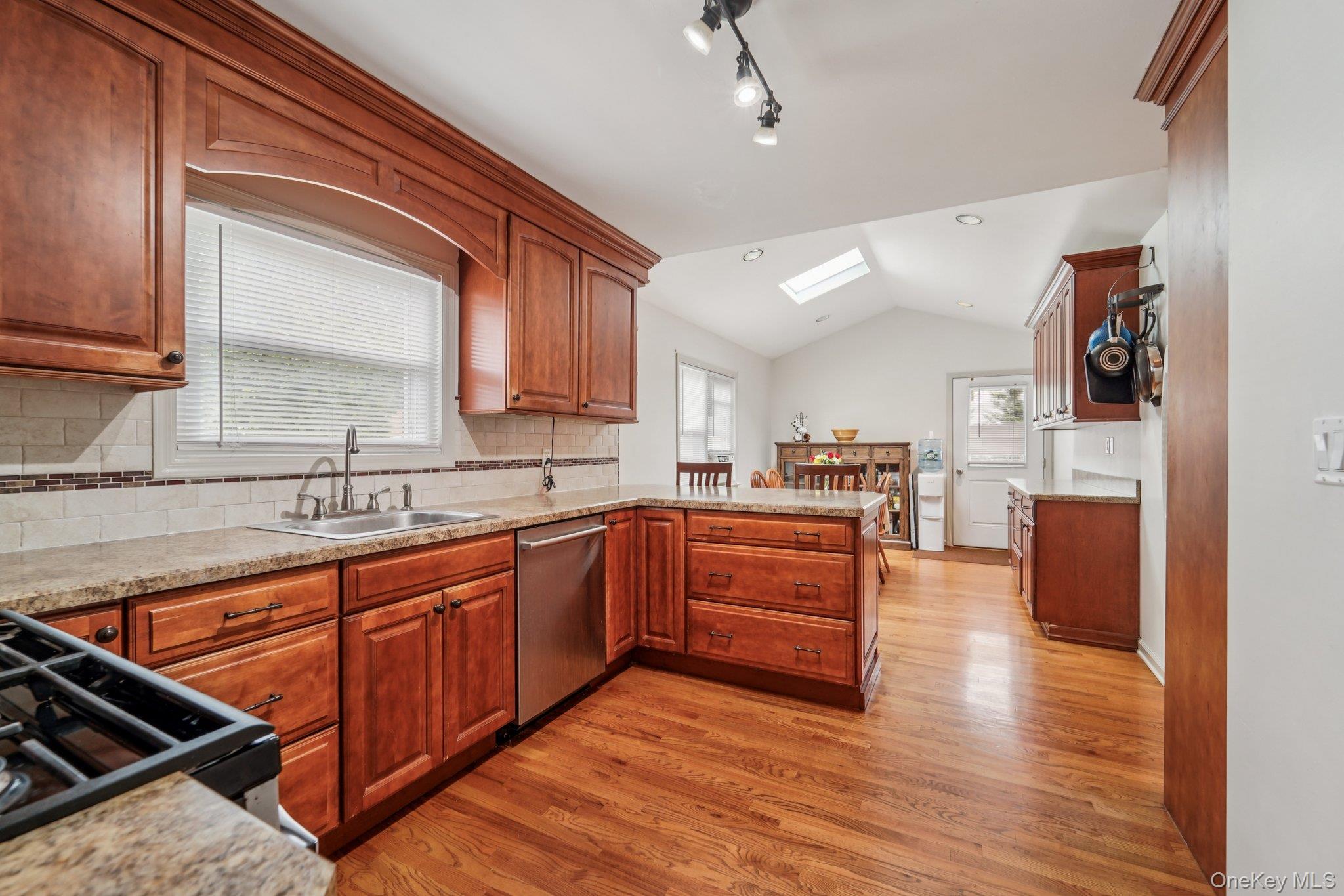 10 Ward Street Suffern, NY 10901 - Photo 11 of 34 Kitchen with dishwasher, black range, a skylight, a peninsula, and light wood-style floors