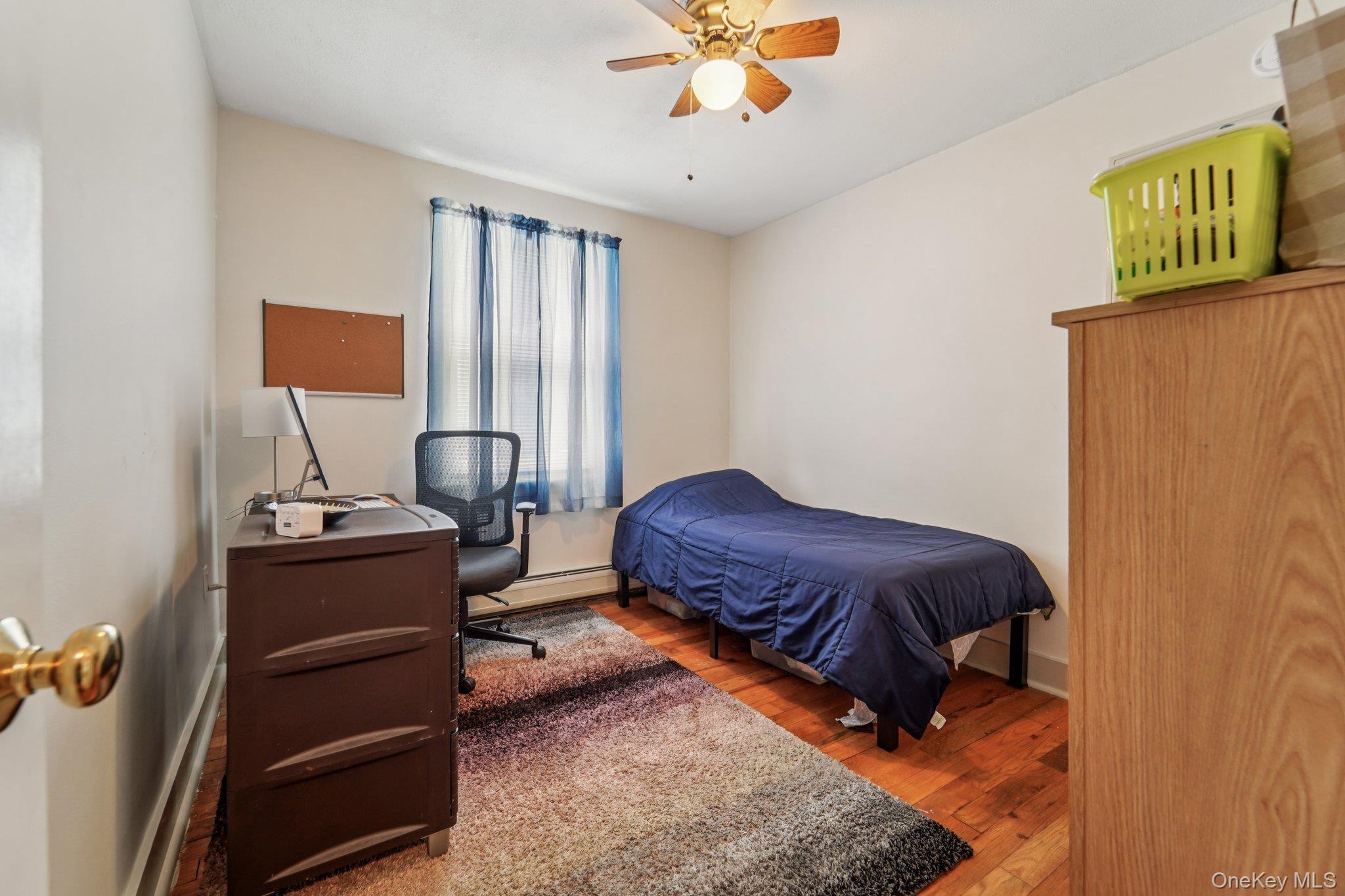 10 Ward Street Suffern, NY 10901 - Photo 15 of 34 Bedroom with wood finished floors, an office area, ceiling fan, and a baseboard radiator