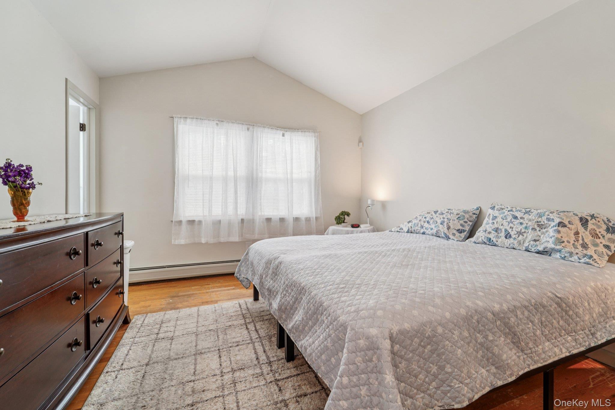 10 Ward Street Suffern, NY 10901 - Photo 18 of 34 Bedroom featuring baseboard heating, light wood-style flooring, and vaulted ceiling