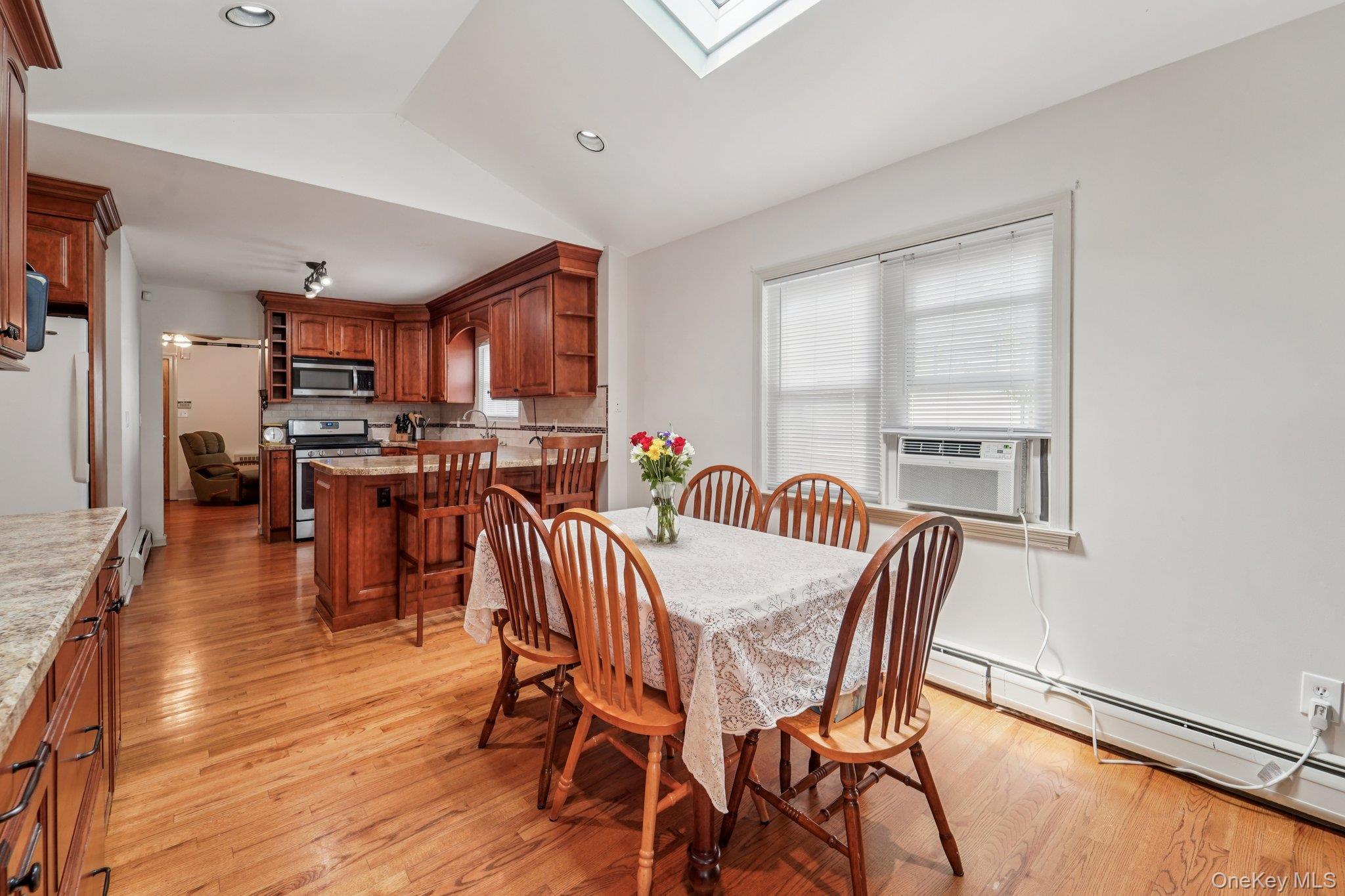 10 Ward Street Suffern, NY 10901 - Photo 8 of 34 Dining space featuring lofted ceiling, light wood finished floors, a baseboard heating unit, cooling unit, and a skylight