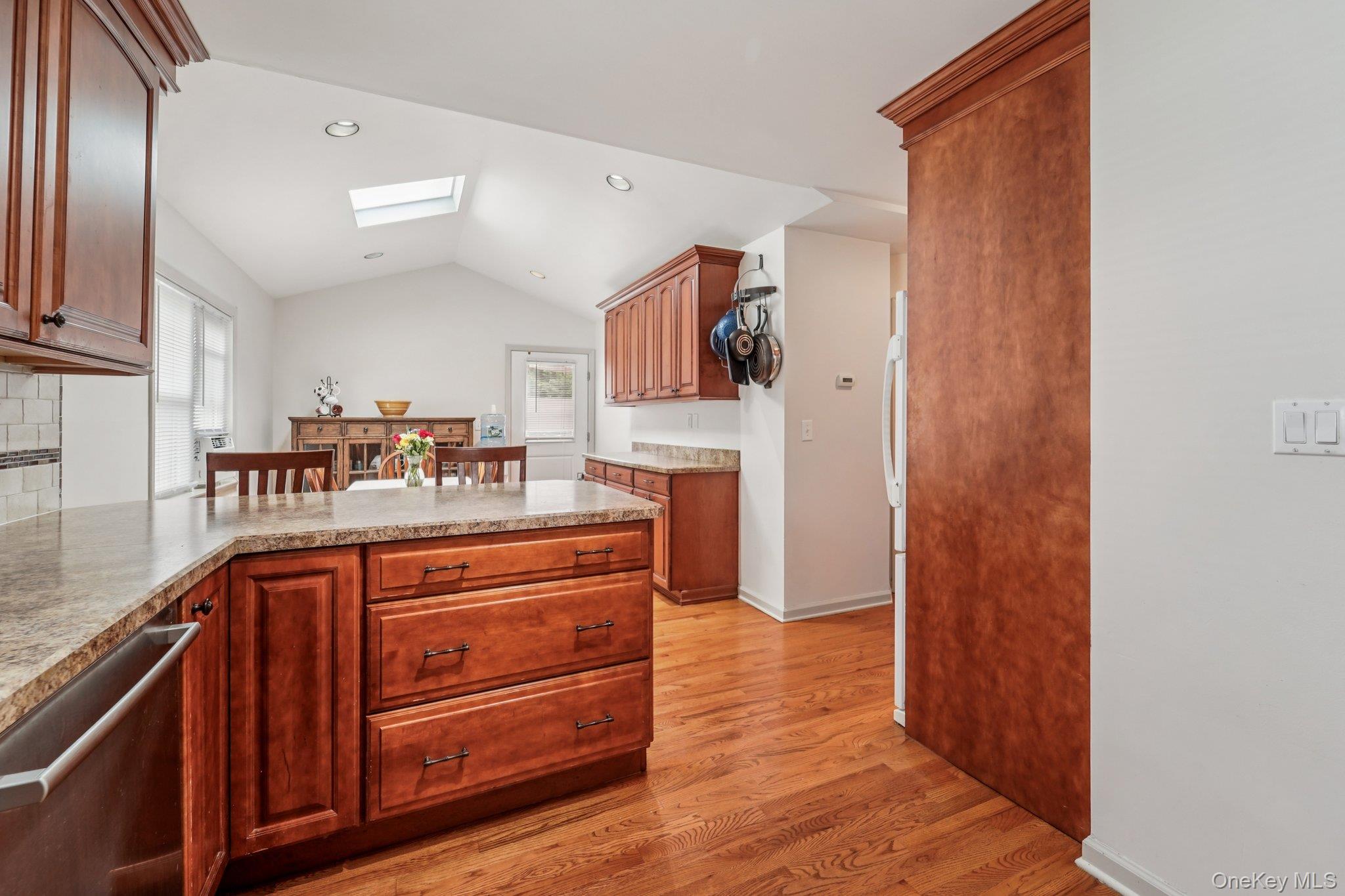 10 Ward Street Suffern, NY 10901 - Photo 10 of 34 Kitchen with stainless steel dishwasher, a skylight, light wood-style floors, vaulted ceiling, and a peninsula