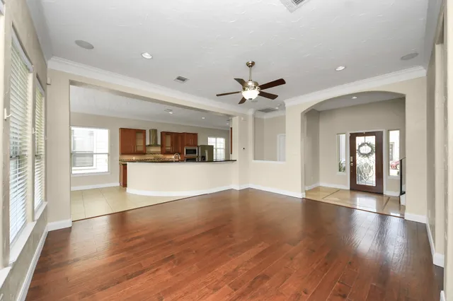 an empty room with wooden floor fireplace and windows