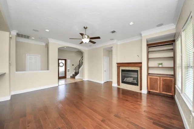 a view of an empty room with a window and wooden floor