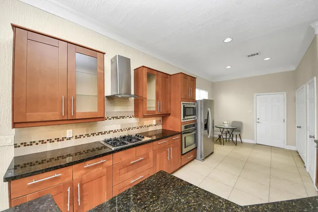 a large kitchen with granite countertop stainless steel appliances a sink and a counter space