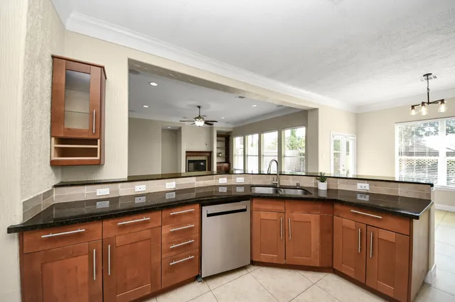 a view of a kitchen with kitchen island granite countertop a refrigerator oven a sink and dishwasher
