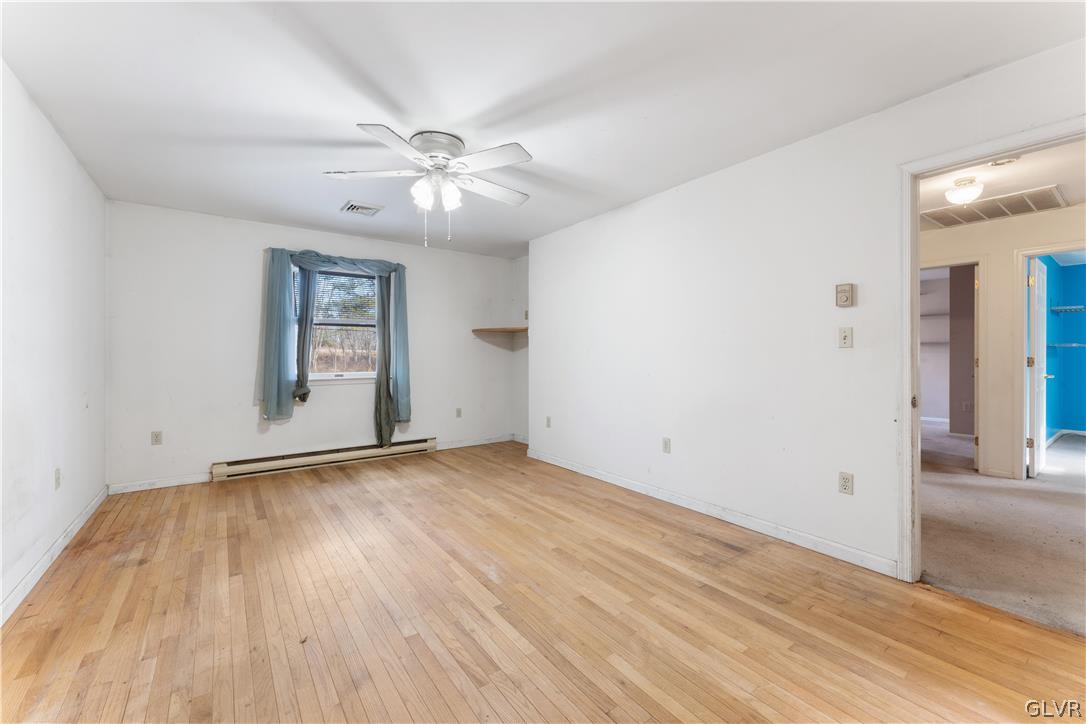 217 Tanite Road Stroudsburg, PA 18360 - Photo 19 of 40 an empty room with wooden floor chandelier fan and windows