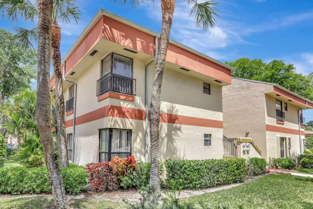 a front view of a multi story residential apartment building with a yard
