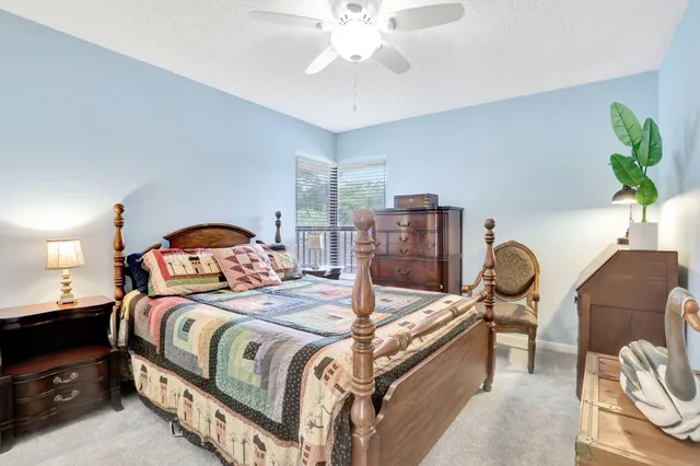 a bedroom with a bed and dresser with potted plants