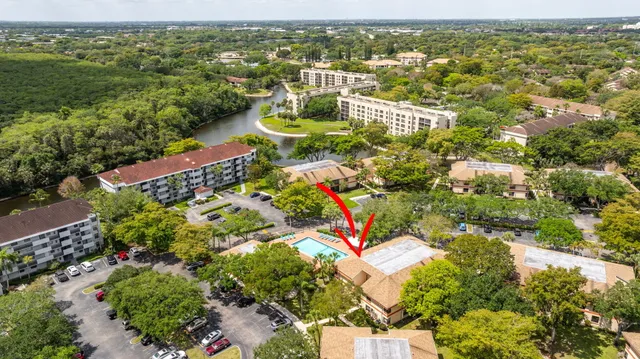 an aerial view of residential houses with outdoor space and trees