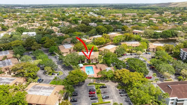 an aerial view of residential houses with outdoor space and trees