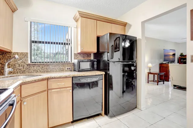a kitchen with a refrigerator sink and cabinets