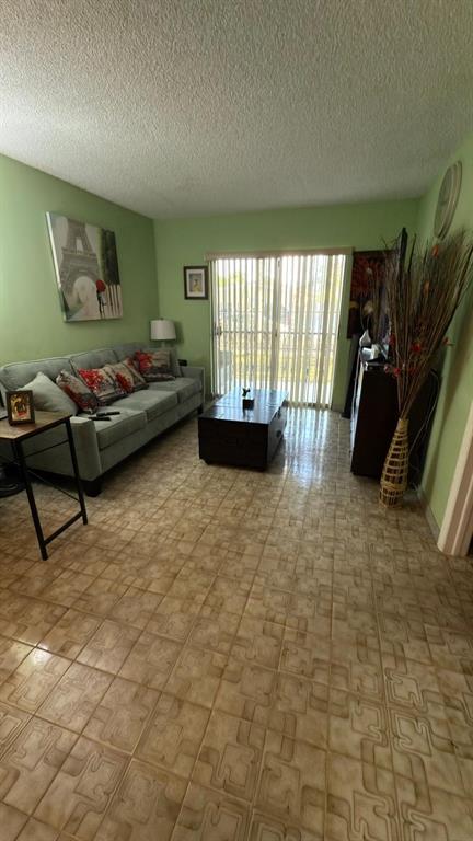 3181 Southwest 13th Street, Unit 114 Miami, FL 33145 - Photo 15 of 17 a living room with furniture and a flat screen tv