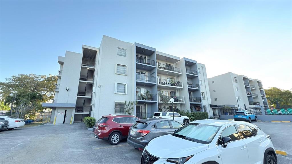 3181 Southwest 13th Street, Unit 114 Miami, FL 33145 - Photo 2 of 17 a cars parked in front of a building
