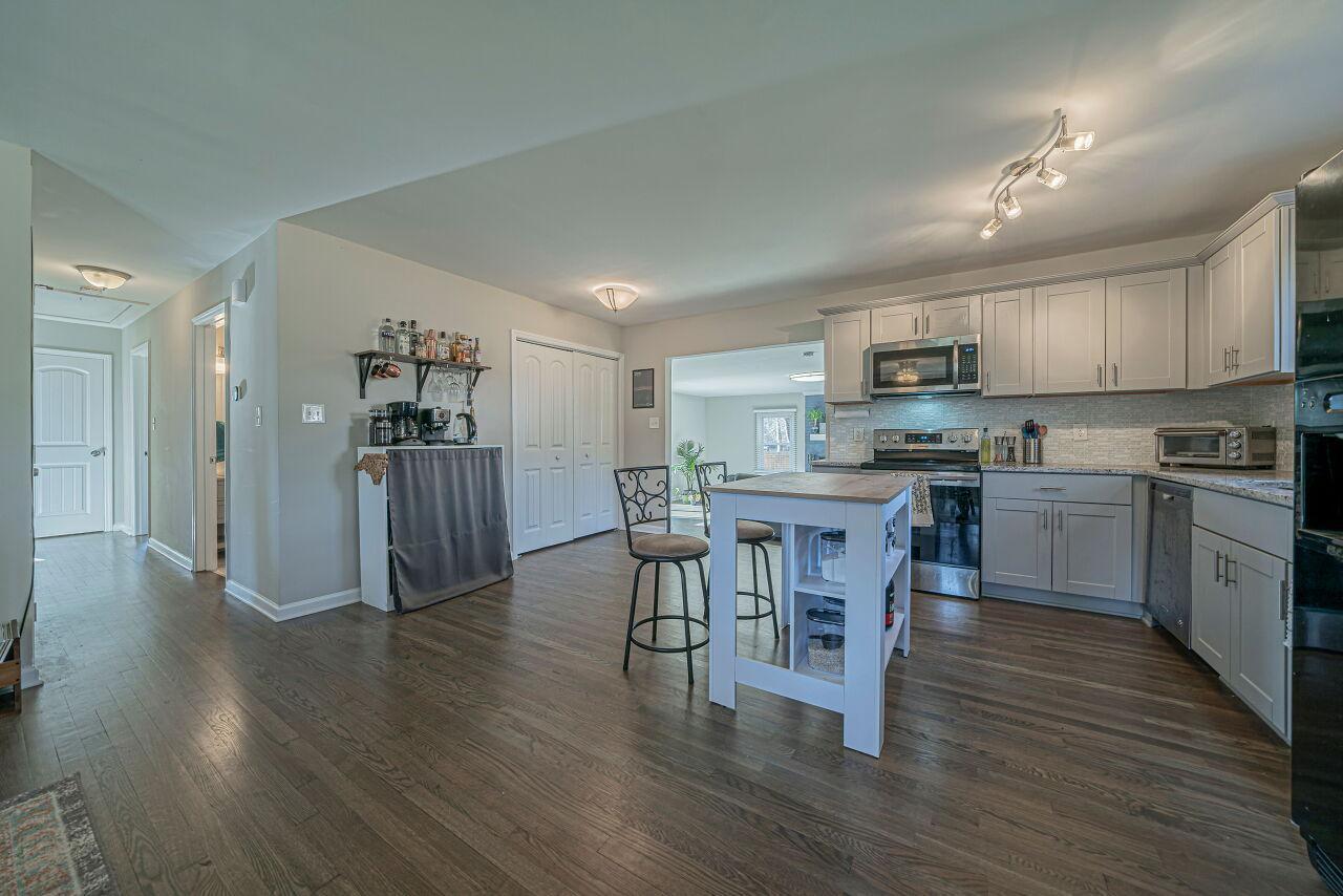 3322 Bell Drive Raleigh, NC 27610 - Photo 12 of 35 a kitchen with stainless steel appliances granite countertop a refrigerator a stove top oven a sink dishwasher and white cabinets with wooden floor