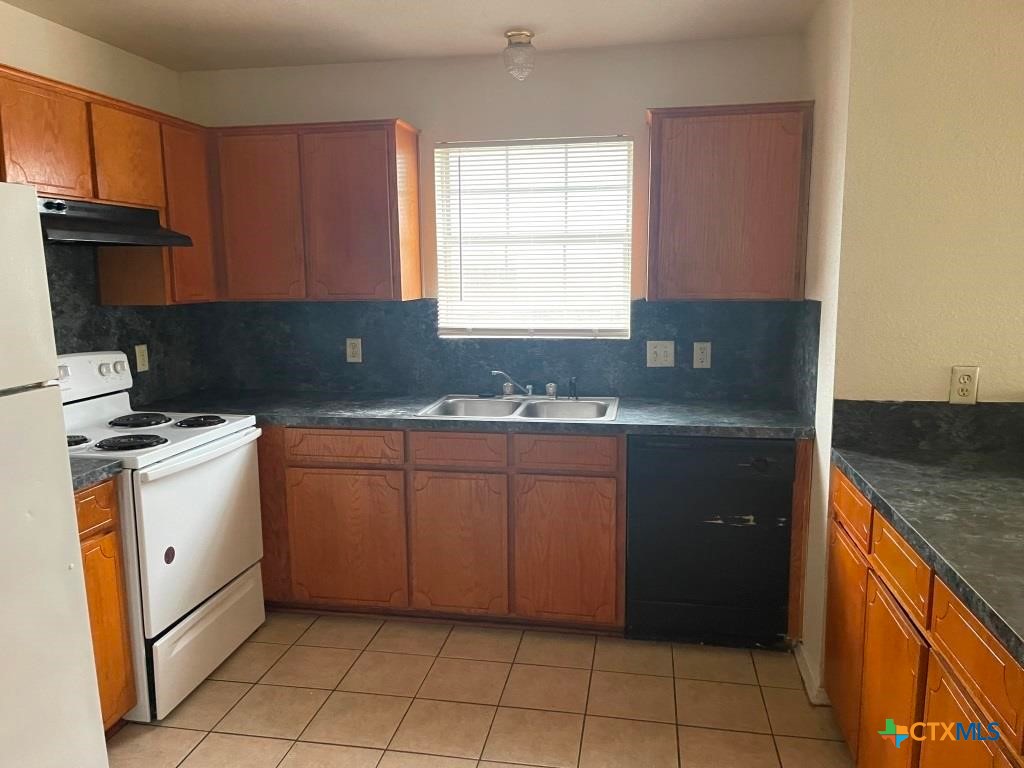 4507 Deek Drive, Unit A Killeen, TX 76549 - Photo 8 of 27 a kitchen with granite countertop a sink a stove and a microwave