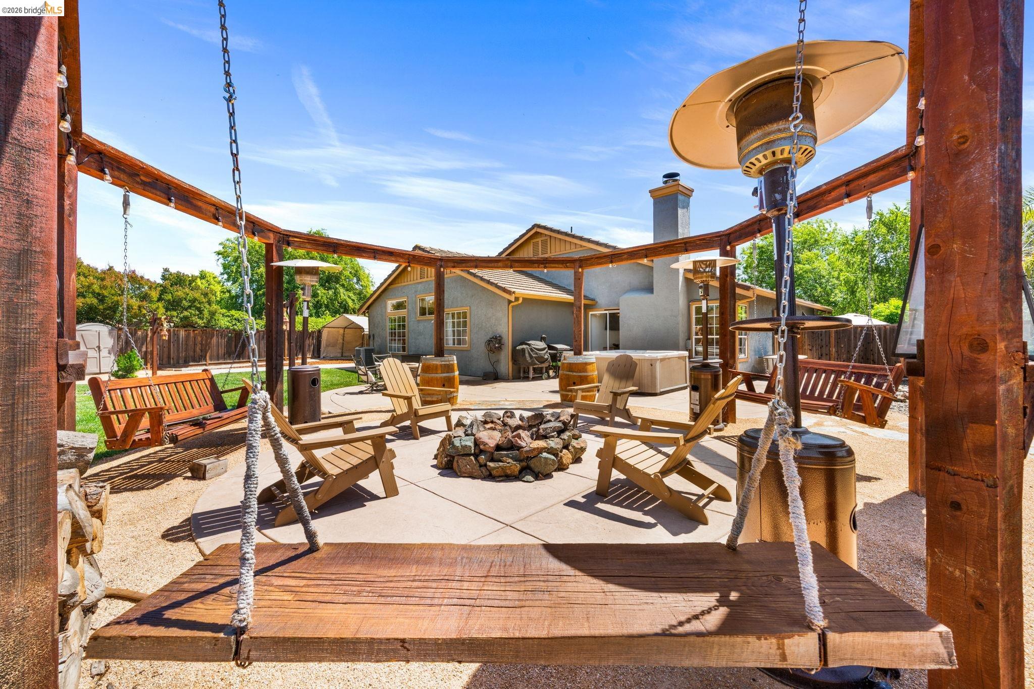 1186 El Rio Court Livermore, CA 94551 - Photo 32 of 60 Outdoor living area featuring a central fire pit, concrete patio, and a wood pergola structure