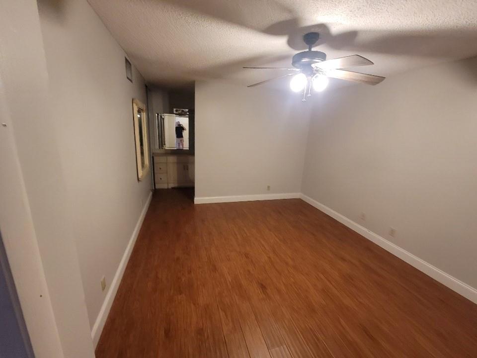 8657 Boca Glades Boulevard, Unit C Boca Raton, FL 33434 - Photo 3 of 6 a view of a hallway with wooden floor and a chandelier