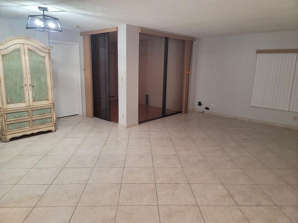 8657 Boca Glades Boulevard, Unit C Boca Raton, FL 33434 - Photo 6 of 6 an empty room with fireplace and windows