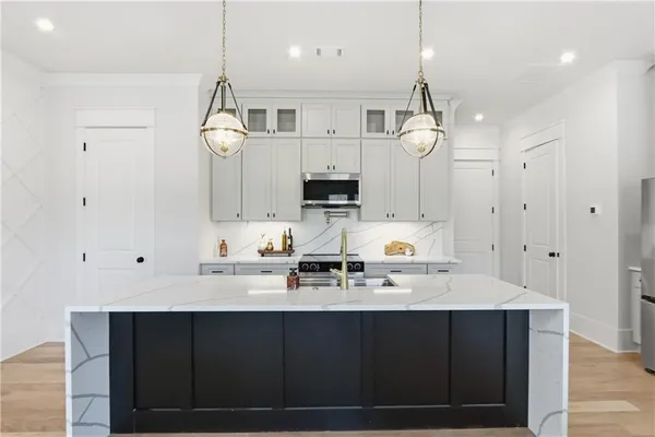 a kitchen with a sink a counter space appliances and cabinets