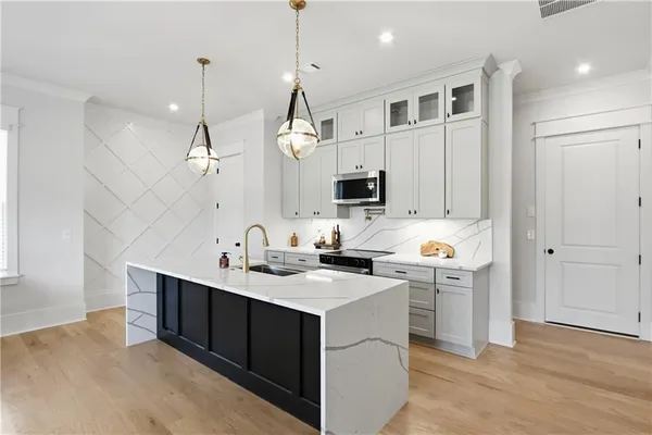 a kitchen with a sink a counter space appliances and cabinets
