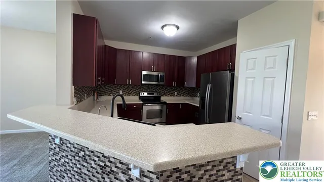 a kitchen with granite countertop a refrigerator stove and sink